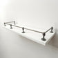 Handcrafted Black Shadow brass gallery rail system full assembly with five posts on a floating white shelf, presented in a clean, clear perspective view.