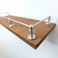 Side angle view focusing on a brushed nickel corner post and rail installed on a wooden shelf edge.