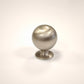 Brushed satin nickel spherical ball drawer knob on a white background for cabinets and dressers.