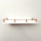 Brass Gallery Rail solid brass gallery rail set with warm copper finish, front view mounted on a floating white wall shelf. – view 4