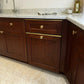 Warm natural wood kitchen cabinets featuring solid brass drawer toppers edge guards paired with brass knobs and marble countertop.