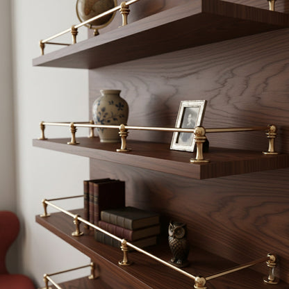 Solid unlacquered brass gallery rail guards mounted on dark walnut wood open floating shelves displaying decor items and books.