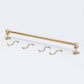 Solid unlacquered brass kitchen hanging rail set displayed flat on a white background with two end brackets and four S-hooks.