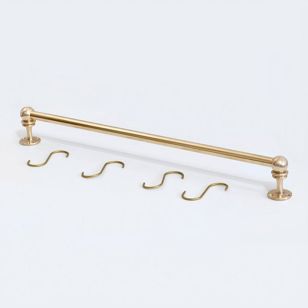 Solid unlacquered brass kitchen hanging rail set displayed flat on a white background with two end brackets and four S-hooks.
