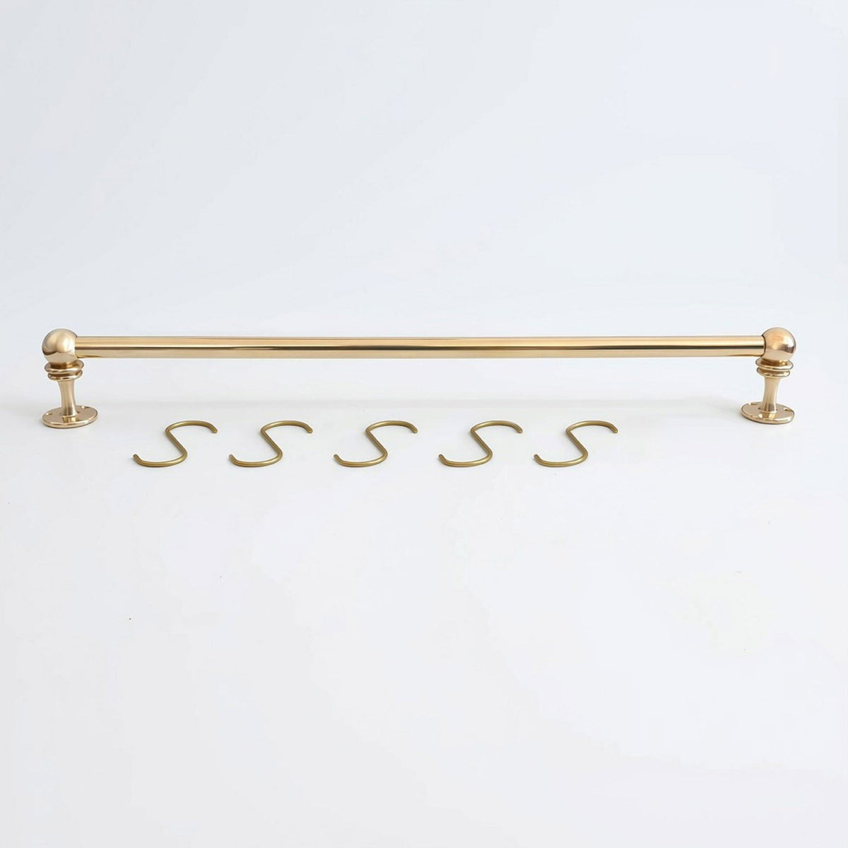 Solid unlacquered brass kitchen hanging rail displayed horizontally with five matching brass S-hooks on a white background.